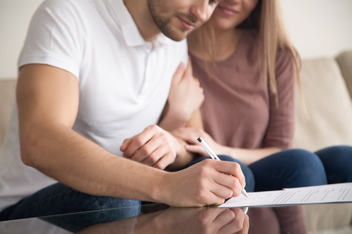 couple signing pre nup agreement